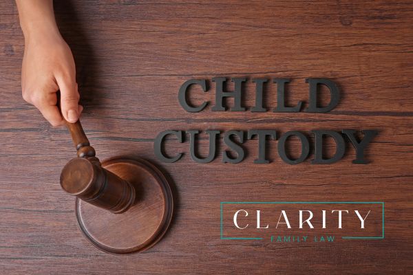 Child Custody being spelled out on a desk next to a person hammering a gavel