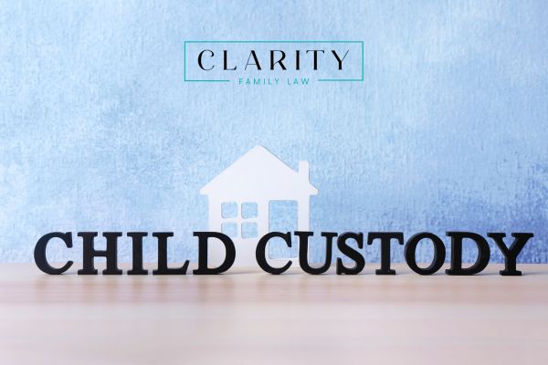 the term child custody spelled out on a desk with a little home behind it